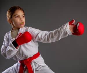 girl in karate outfit with mouth guard in mouth